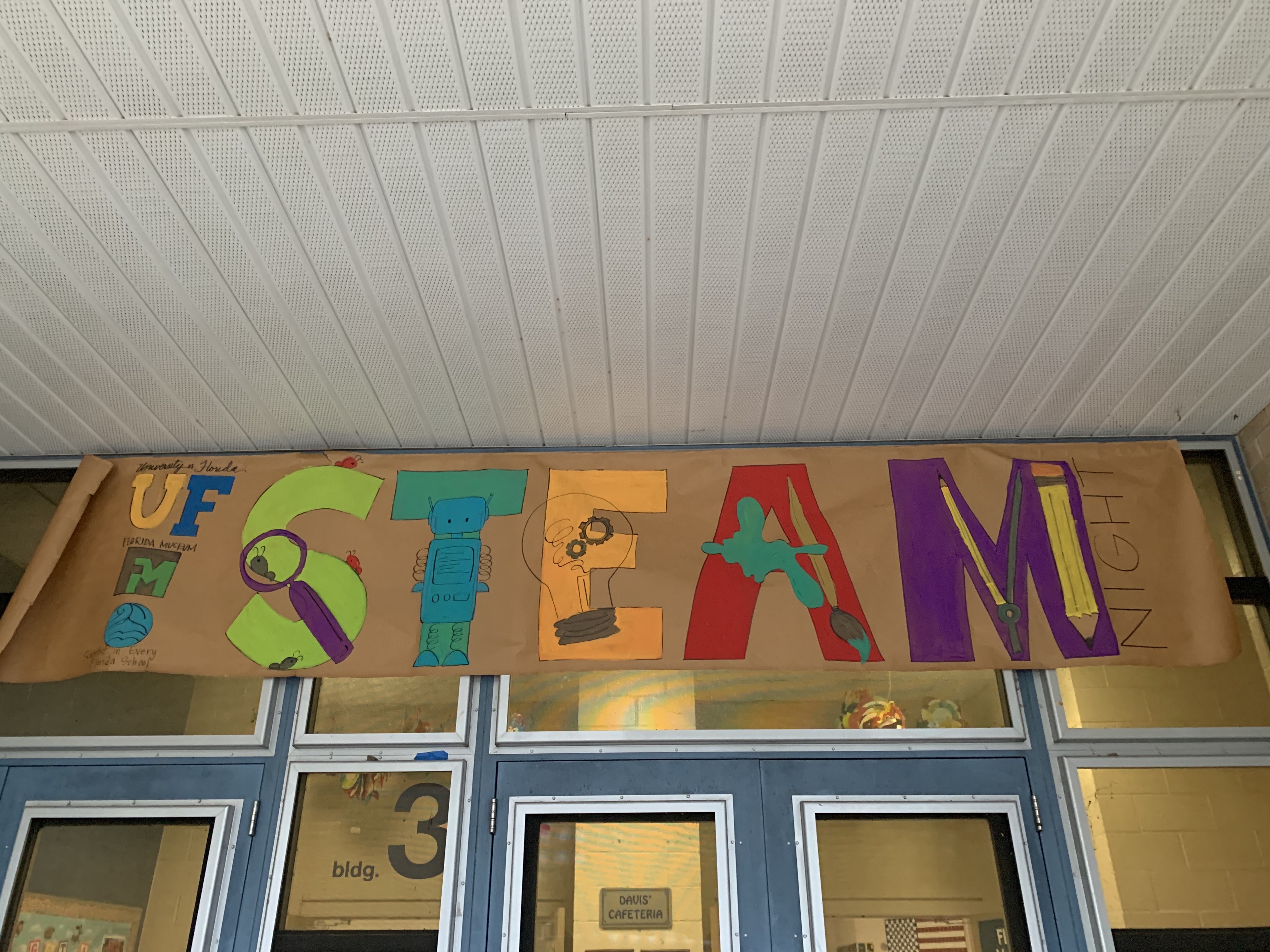 A brown poster with the words STEAM Night. Hosted by UF, Florida Museum, & TESI